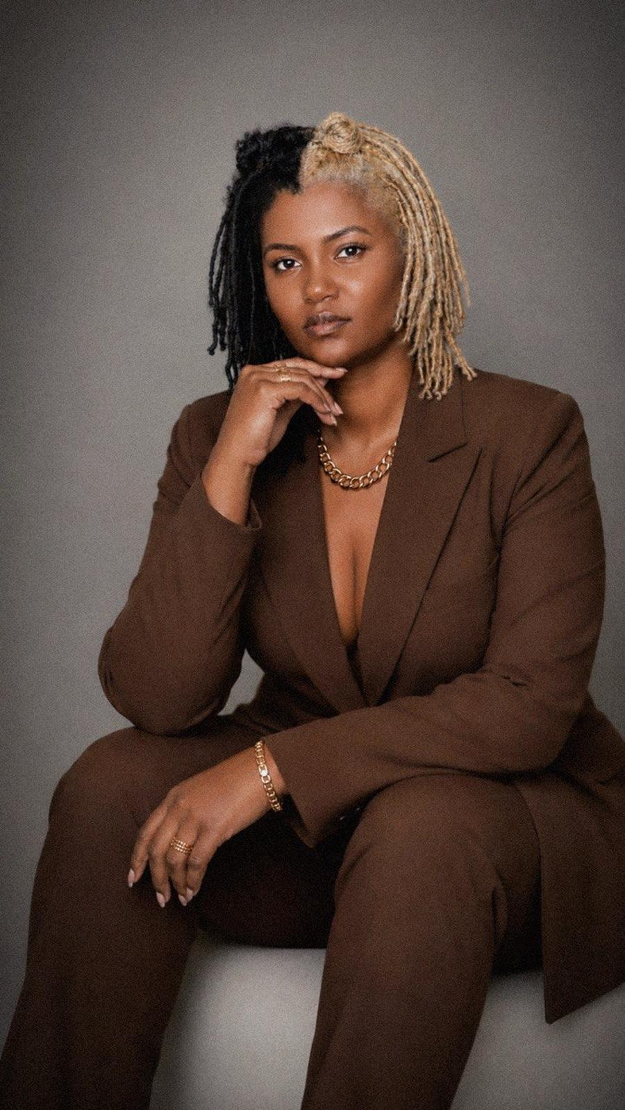 Coach Deb, founder of Contour Gains, seated in a brown suit